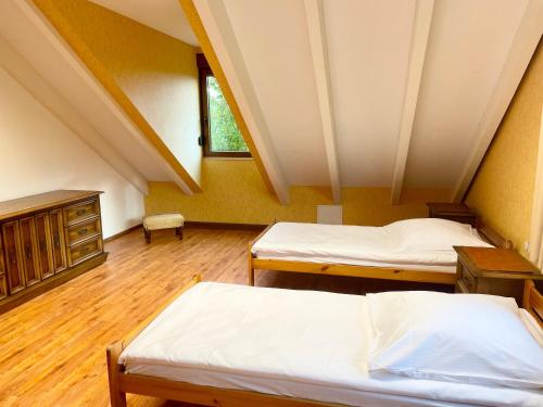 two beds in a room with a attic at Gästewohnung auf Gold's Obsthof in Karlburg