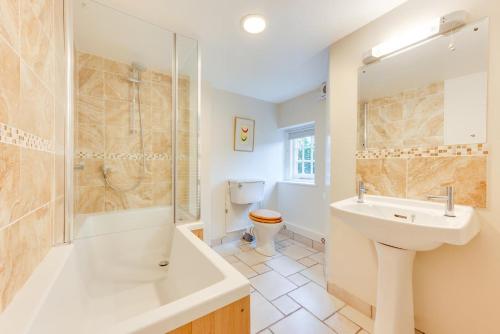 a bathroom with a sink and a shower and a toilet at Garden Flat in Sandwich