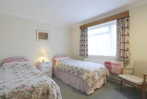 a bedroom with two beds and a window at Midda Beck in Aldringham