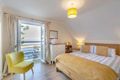 ein Schlafzimmer mit einem Bett und einem Stuhl und einem Fenster in der Unterkunft Pebblesea in Whitstable