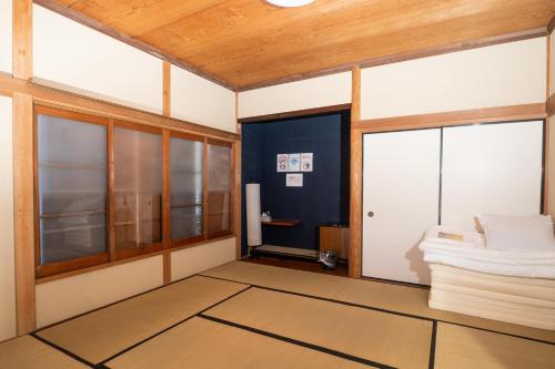 una habitación con una puerta y ventanas en ＳｅａＳａｉｄｅＨｏｕｓｅ湯河原, en Yugawara