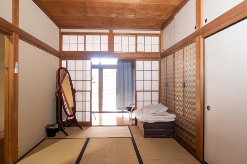 Habitación con espejo y puerta. en ＳｅａＳａｉｄｅＨｏｕｓｅ湯河原, en Yugawara