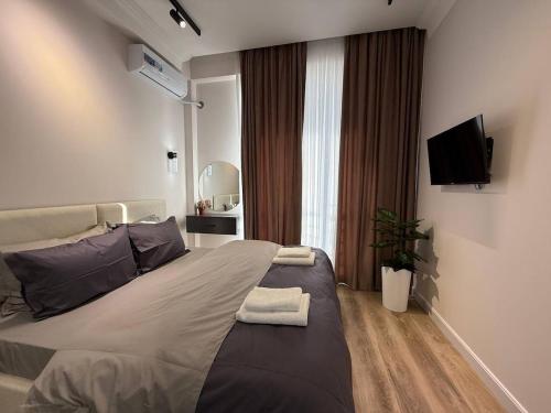 a bedroom with a large bed and a television at Modern spaces 12 in Yunusobod