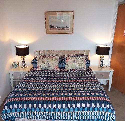 a bedroom with a bed with two lamps on two tables at Regis Lodge Guest House in Bognor Regis
