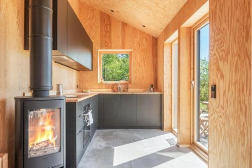 a kitchen with a fireplace and a stove at Architect-Designed House Overlooking Valö Fjord in Hamburgsund
