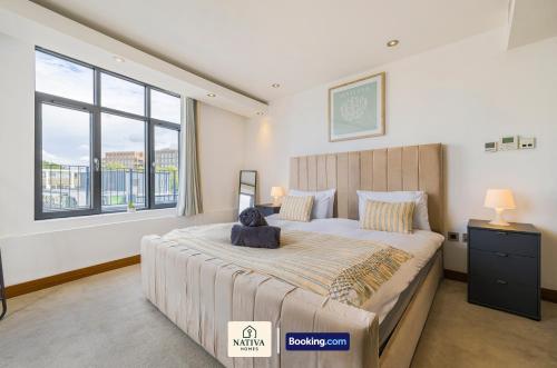 a bedroom with a large bed and a large window at Spacious 2BR, 2BA Apt By Nativa Homes Short Lets & Serviced Accommodation Harrow With Fast WiFi, Kitchen in Harrow