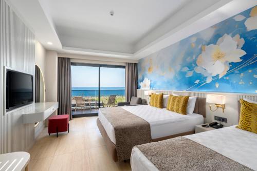 een hotelkamer met twee bedden en een televisie bij Arsuz Jumanah Hotel in Arsuz