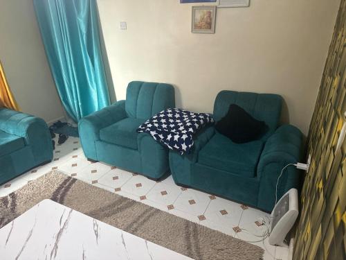 ein Wohnzimmer mit einer grünen Couch und einem Stuhl in der Unterkunft Home Sweet Home in Kisii