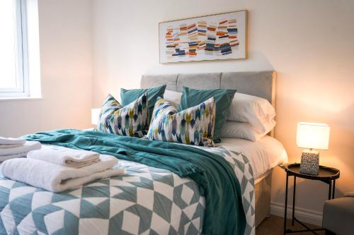 a bedroom with a bed with a blanket and pillows at Luxury 3 Bedroom Welsh Valley Retreat With Superfast Wifi in Tredegar