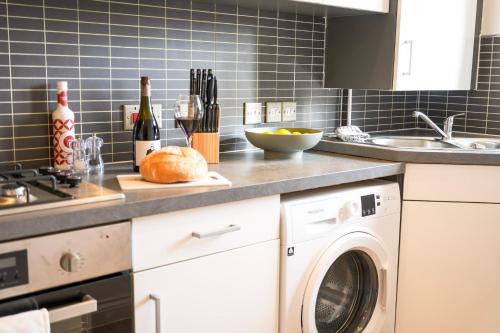 a kitchen with a washing machine and a sink at Luxury 3 Bedroom Welsh Valley Retreat With Superfast Wifi in Tredegar