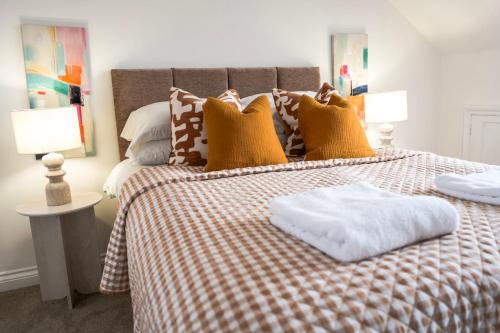 a bed with a checkered blanket and pillows on it at Luxury 3 Bedroom Welsh Valley Retreat With Superfast Wifi in Tredegar