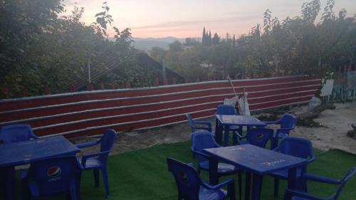 a group of blue tables and chairs on the grass at River BPR Hostel in Tbilisi City