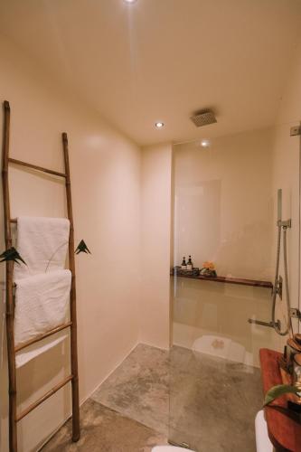 a bathroom with a ladder and towels on a wall at UNLTD Hotel Siargao in General Luna