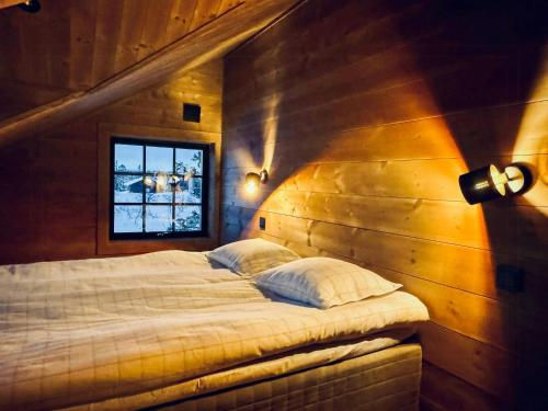 a bedroom with a bed in a wooden wall at Mountain Cabin With Views Over Jämtland's Expanse in Storhågna