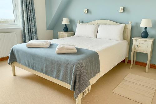 een slaapkamer met een bed met twee handdoeken erop bij Beachy Days and Family Stays in Nairn