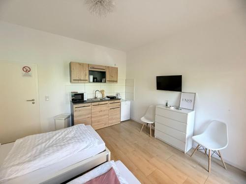 バート・エーンハウゼンにあるLoft am Kurpark, nähe Kurpark, GOP, Balitherme, mit Waschmaschine u Kücheのベッドとキッチンのある小さな部屋