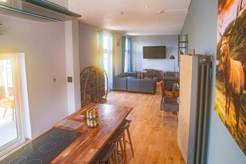 eine Küche und ein Wohnzimmer mit einem Tisch und einer Couch in der Unterkunft Seaview Cottage Schoolhouse 2 in Carbost