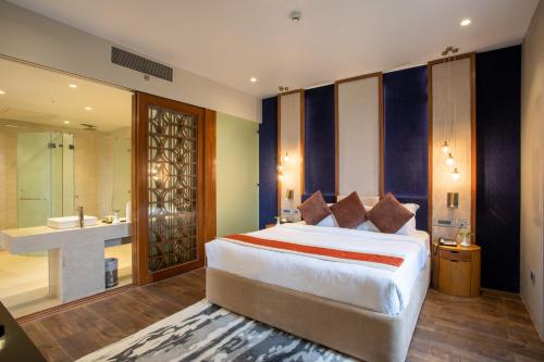 une chambre avec un grand lit et une salle de bain dans l'établissement Hotel Lumbini Heritage, à Rummindei