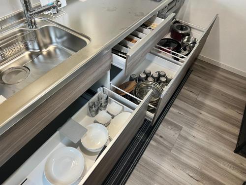 eine Küche mit offener Schublade mit Geschirr in der Unterkunft Fabulous Shiroyama - Vacation STAY 17734 in Odawara