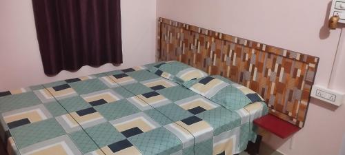 a bed with a wooden headboard in a bedroom at Backpackers' Haven in Guwahati