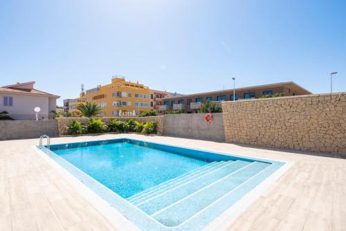 een zwembad voor een gebouw bij MEDANO4YOU The Surf Backyard in El Médano