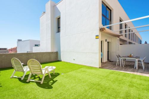 een patio met tuinstoelen en een tafel bij MEDANO4YOU The Surf Backyard in El Médano