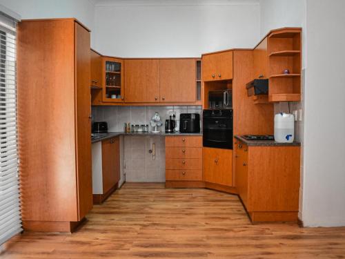 a large kitchen with wooden cabinets and appliances at Splendid Village in Beaufort West