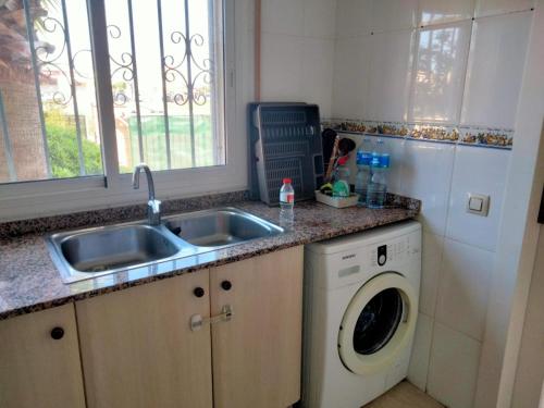 a kitchen with a sink and a washing machine at casa Palm Beach in Montroig