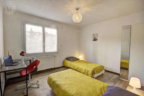 a bedroom with two beds and a desk and a desk at Le sorberan in Sorbiers