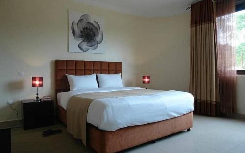 een slaapkamer met een groot bed en twee lampen bij Le Ptit Zinc in Kigali