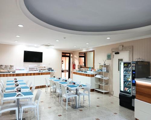 un ristorante con tavoli blu e sedie bianche di Hotel Riviera Fiumicino a Fiumicino