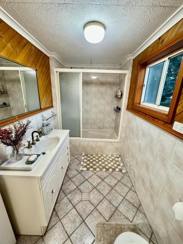 ein Badezimmer mit Badewanne, Waschbecken und Dusche in der Unterkunft 2 Bedroom Beauty, The Range in The Range