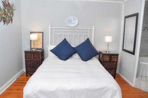 a bedroom with a large white bed with blue pillows at Anker Guesthouse in Philippolis