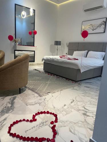 a bedroom with a bed and a heart on the floor at شاليه هوانا in Sohar