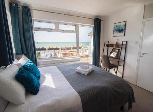 een slaapkamer met een bed met uitzicht op de oceaan bij Marine Villa By Air Premier in Saltdean