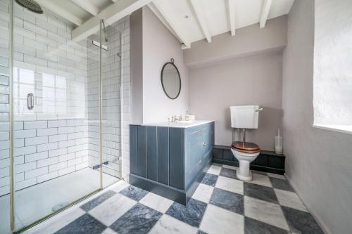 a bathroom with a sink and a toilet and a tub at Garden House in Burnham Market