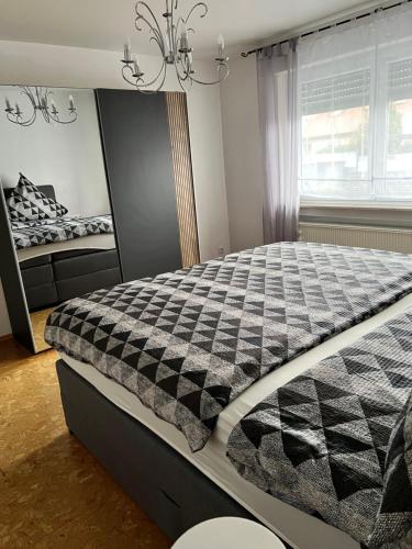 a bedroom with a black and white comforter on a bed at Herz der Weinberge in Gemmrigheim