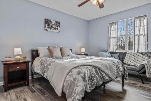 a bedroom with a bed and a chair and a window at Woodstone Retreat right next to UGA golf course in Athens