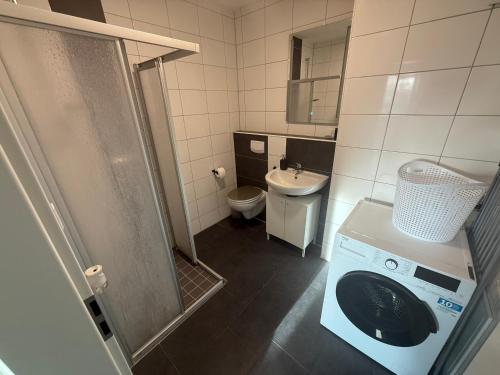 een badkamer met wasmachine en toilet bij ISL Hotel in Gronau