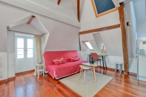a living room with a red couch and a table at Appartement Aiguillon in Le Croisic
