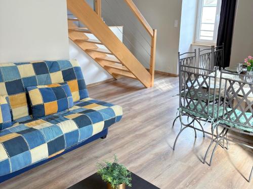 a living room with a couch and a staircase at Les Glaneuses gîte Entre Amis centre-bourg à 3 min du Puy duFou in Les Épesses
