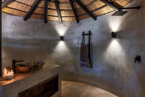 a bathroom with a sink and a counter with lights at Sibani Lodge - Glamping Tents in Krugersdorp