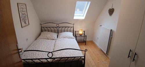 a bedroom with a metal bed with pillows and a window at Ferienwohnung Alte Scheune in Westerburg