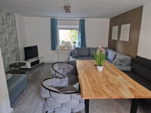 ein Wohnzimmer mit Tisch und Couch in der Unterkunft Nahe Kiel, 4 Betten, 2 Schlafzimmer Parkplatz, Terrasse, 3km zum Strand in Osdorf