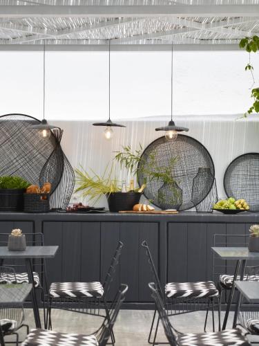 een restaurant met stoelen en tafels en een bar bij Hotiday Mykonos Agios Stefanos in Agios Stefanos