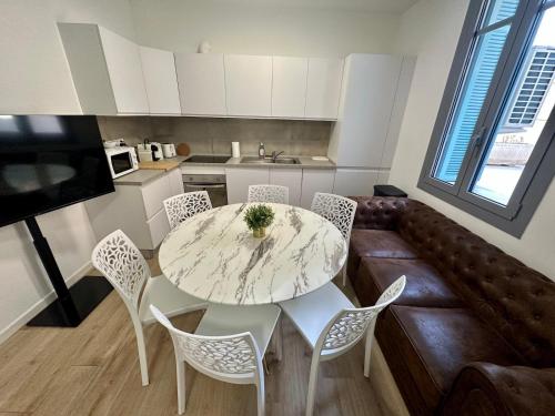 Monaco Villa BRIGITTE Terrasse في بوسولاي: مطبخ مع طاولة وكراسي في الغرفة