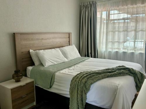 a bedroom with a large bed and a window at Tana's flat in Brakpan