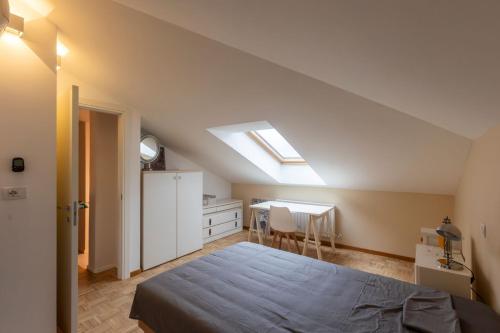 a bedroom with a bed and a table and a skylight at Cardarelli Loft Macerata in Macerata