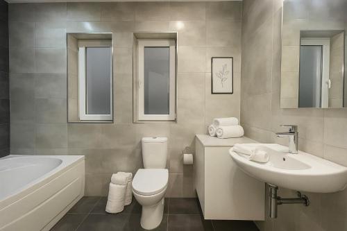 Un baño con inodoro, lavabo y bañera. en Seaview Cozy Stay in a Prime Sliema Location 6S, en Sliema