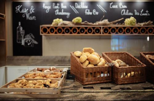 eine Theke mit Körben mit Brot und Gebäck in der Unterkunft Strandhotel Fischland in Dierhagen
